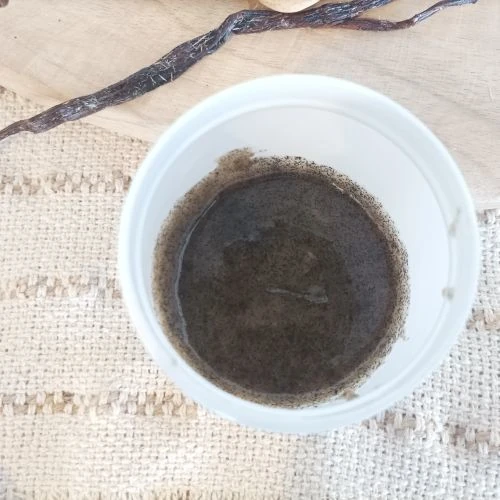 Pâte de vanille dans un pot en plastique blanc sur un linge en toile de jute
