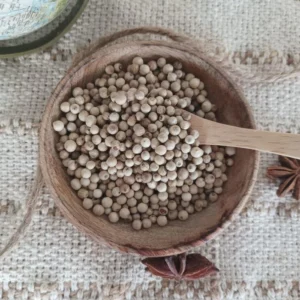 Poivre de penja blanc vu de haut dans une petite coupelle en bois