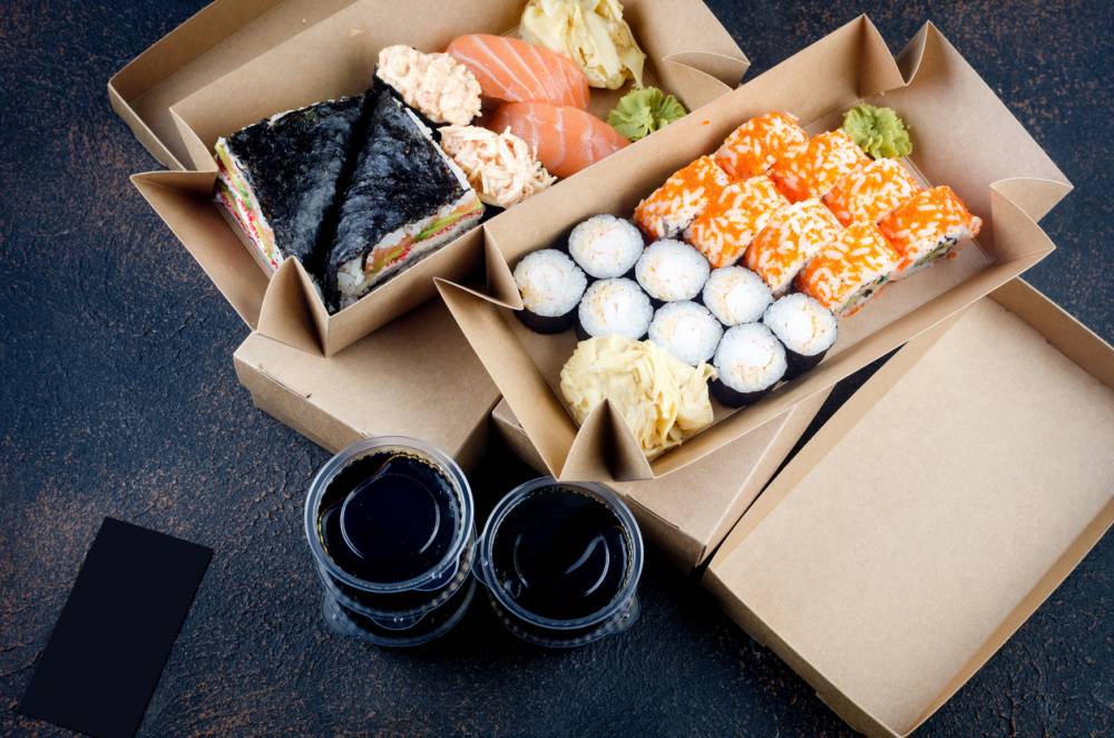 Des emballages alimentaires en carton qui contiennent des sushis et de la nourriture japonnaises (sushi, sashimi)